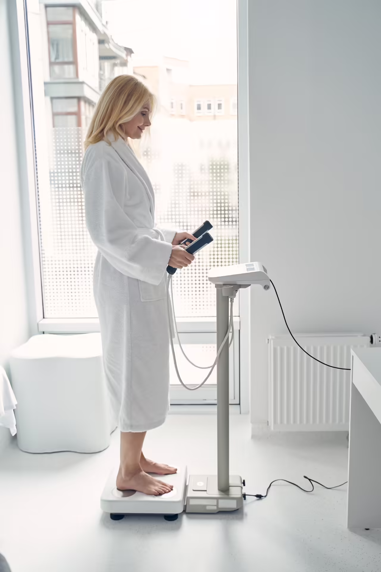 woman in robe using body composition analyzer 2026 03 10 03 10 24 utc